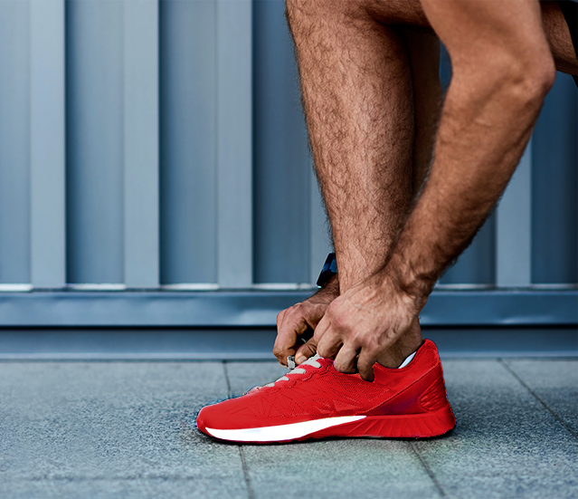 Active man tying red shoe